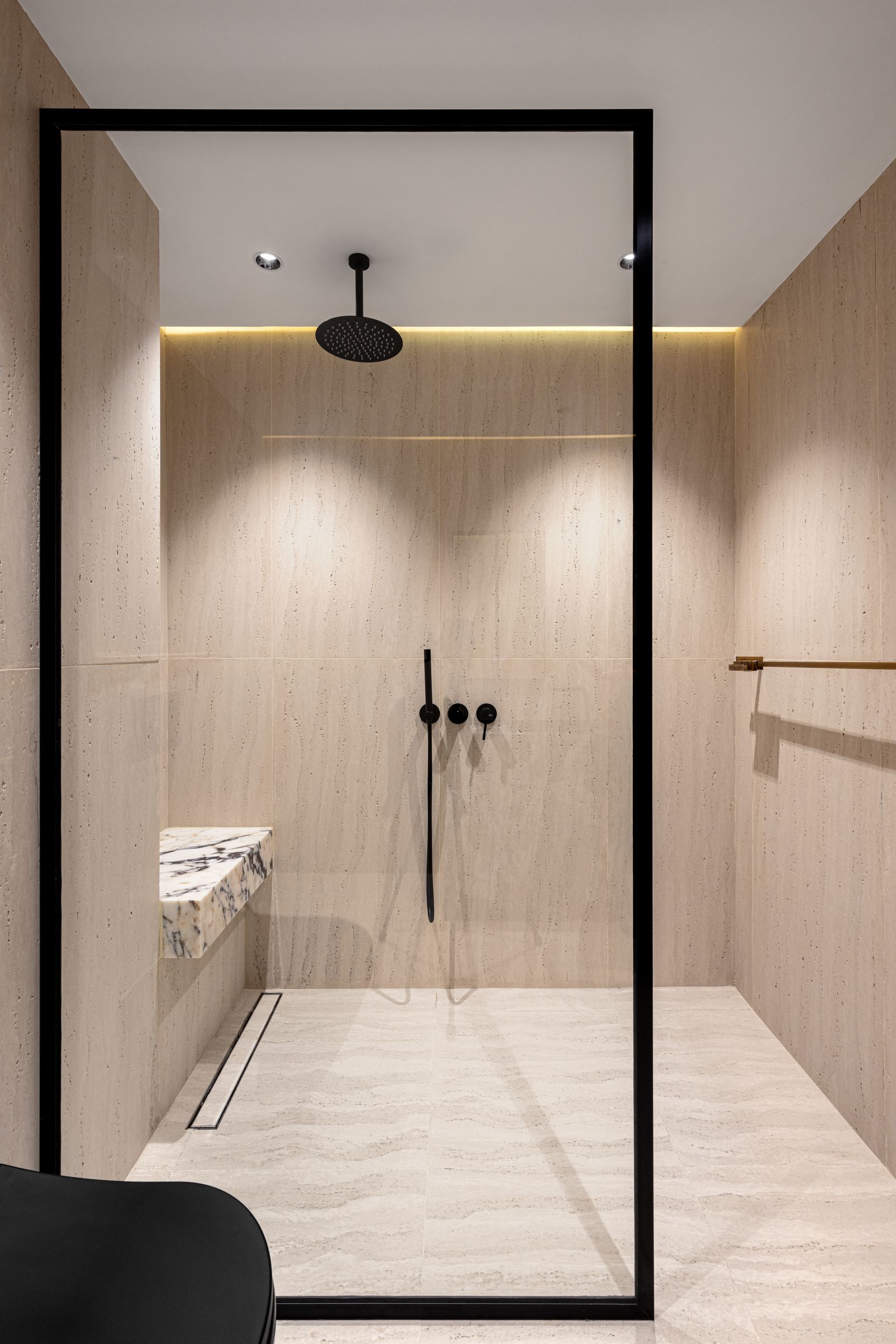 Travertine walk-in shower with matt black rainfall head
