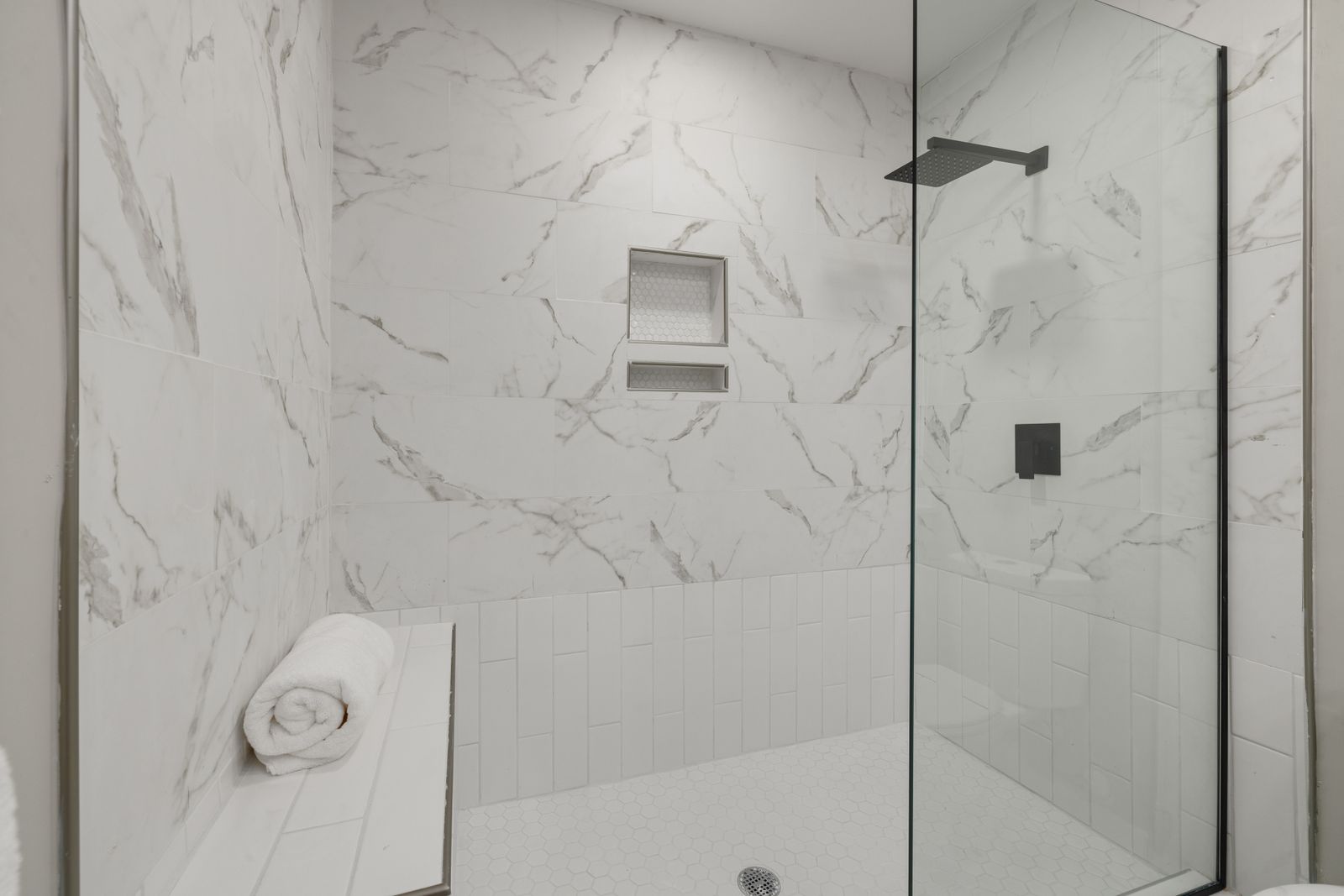 Marble walk-in shower with black rainfall head
