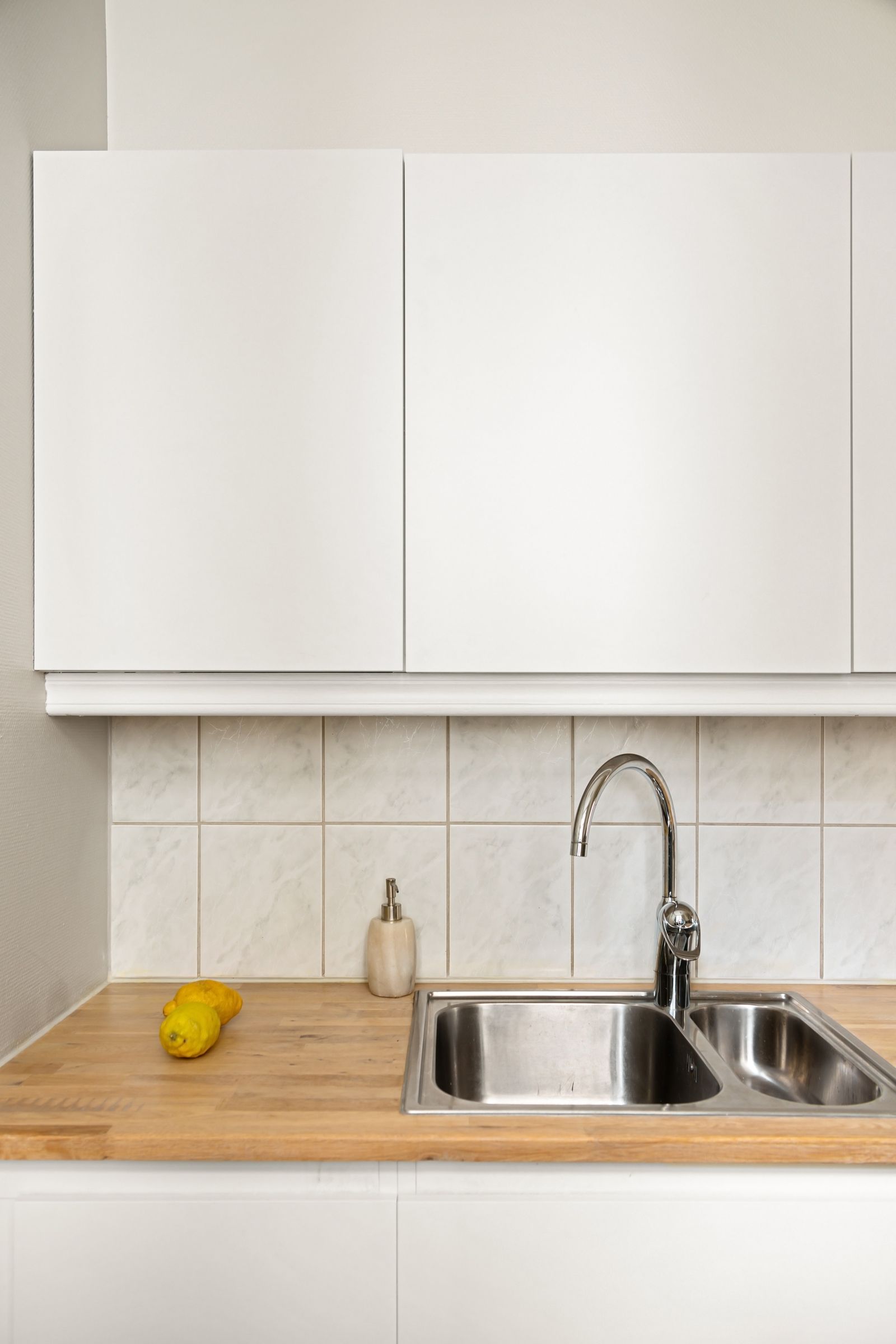 White kitchen with oak worktop and tiled splashback